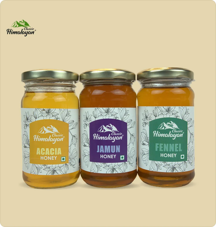 Three glass jars of Classic Himalayan honey -  Acacia Honey, Jamun Honey, and  Fenel Honey.