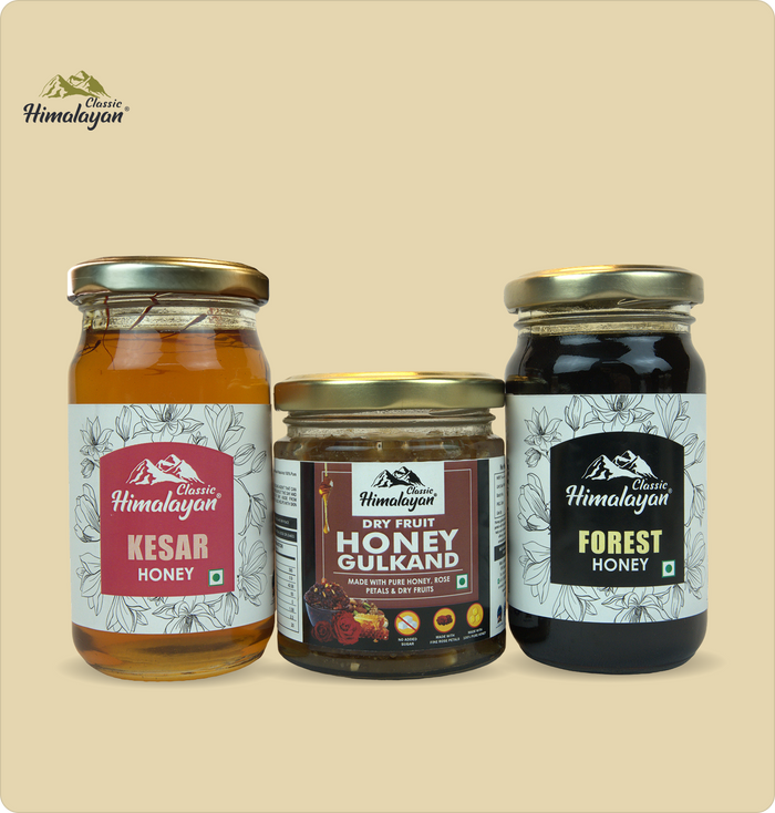 Three glass jars of Himalayan products on a beige background: Classic Himalayan Kesar Honey, Dry Fruit Honey Gulkand, and Forest Honey.