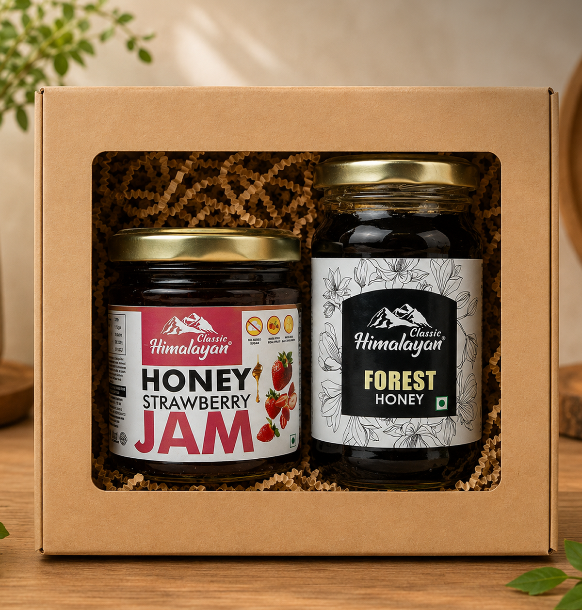 A gift box containing two jars of Himalayan honey: a jar of strawberry jam and a jar of forest honey, displayed on a wooden surface.