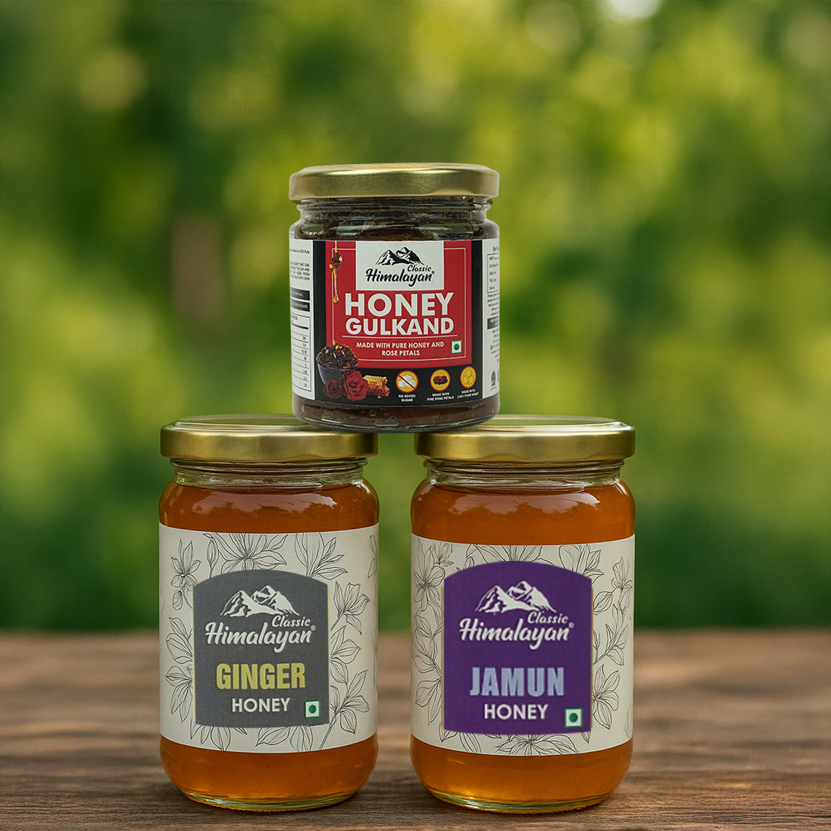 Three jars of honey from Classic Himalayan on a wooden surface with a blurred green background