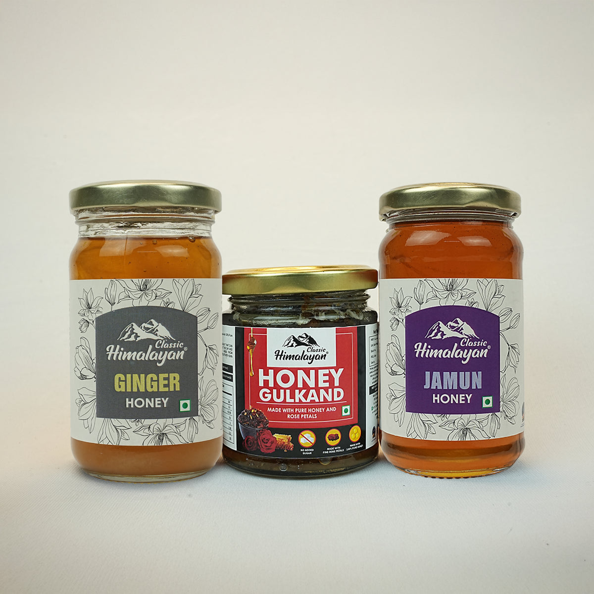 Three jars of honey with labels on a white background