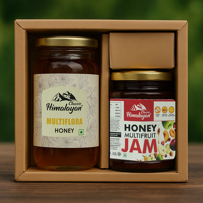 Two jars of honey and jam in a cardboard box with a green background